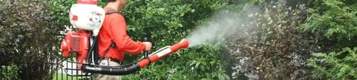 Mosquito control technician fogging shrubs and landscaping for mosquito treatment in Miami, FL